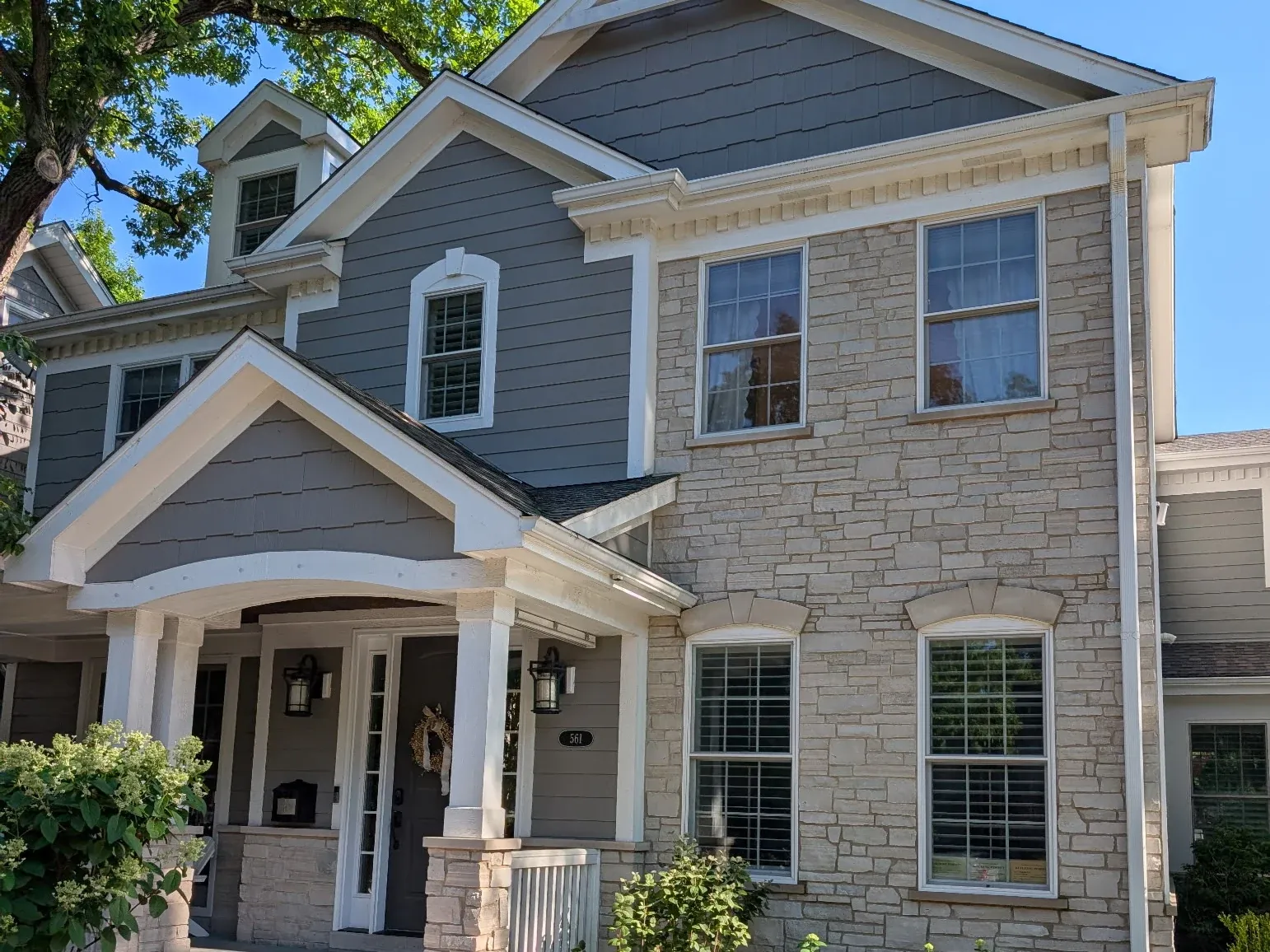 Two-story Chicagoland home with freshly painted gray siding, crisp white trim, and a stone facade